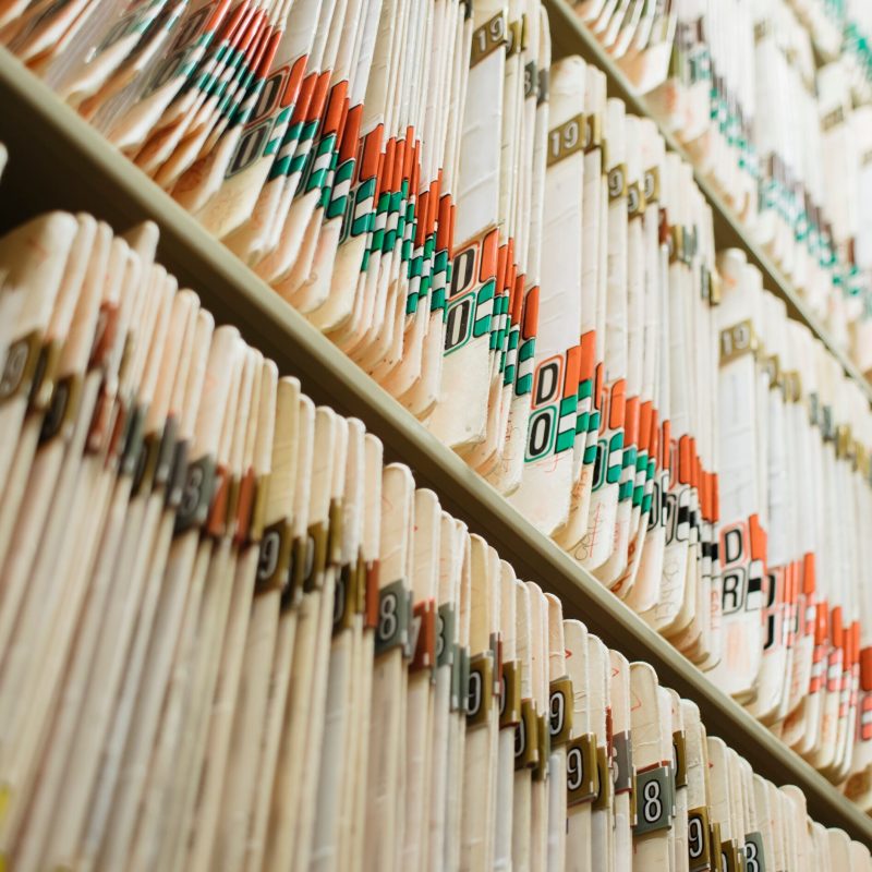 various medical record charts and folders in cabinet and on shelve sorted alphabetically and numerically